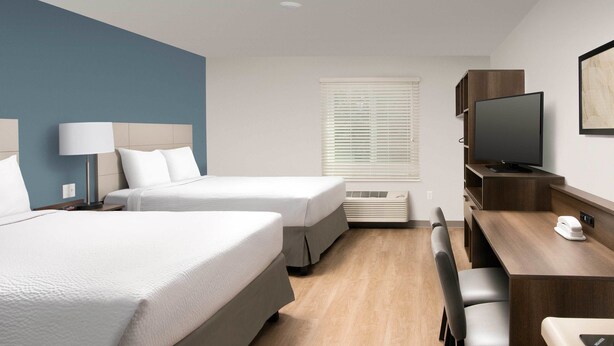 A hotel room with two beds, a desk, a chair, a TV, and a window with blinds. - Extended Stay America Suites - Minneapolis - Fridley (Fridley)