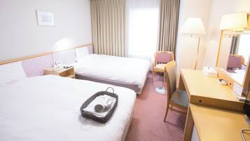 Une chambre d’hôtel avec deux lits, un bureau, une chaise, une lampe et une fenêtre avec des rideaux.