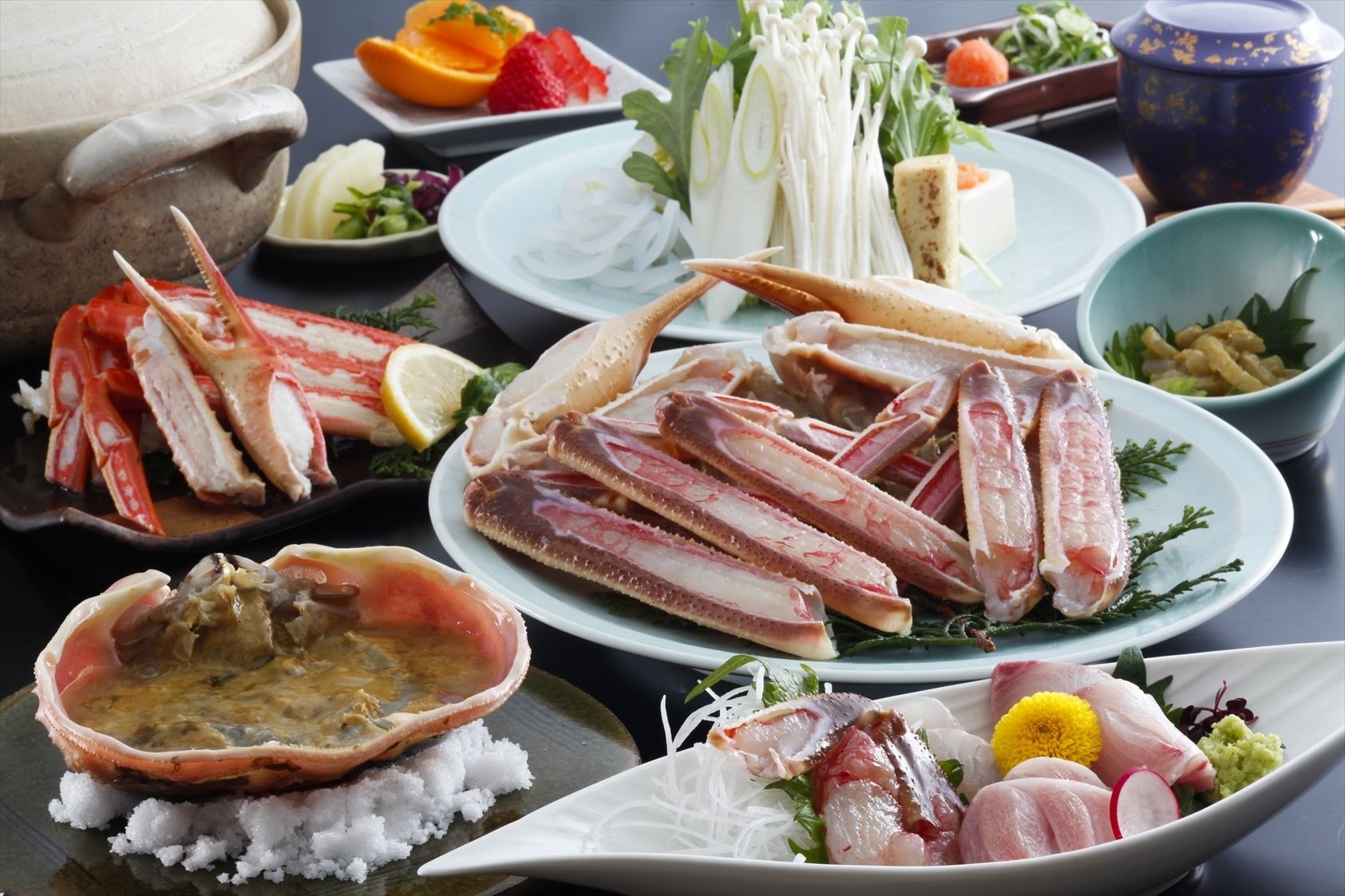 A variety of seafood dishes including crab legs, oysters, and fish, served on plates with garnishes and side dishes.