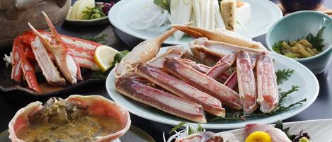 A variety of seafood dishes including crab legs, oysters, and fish, served on plates with garnishes and side dishes.