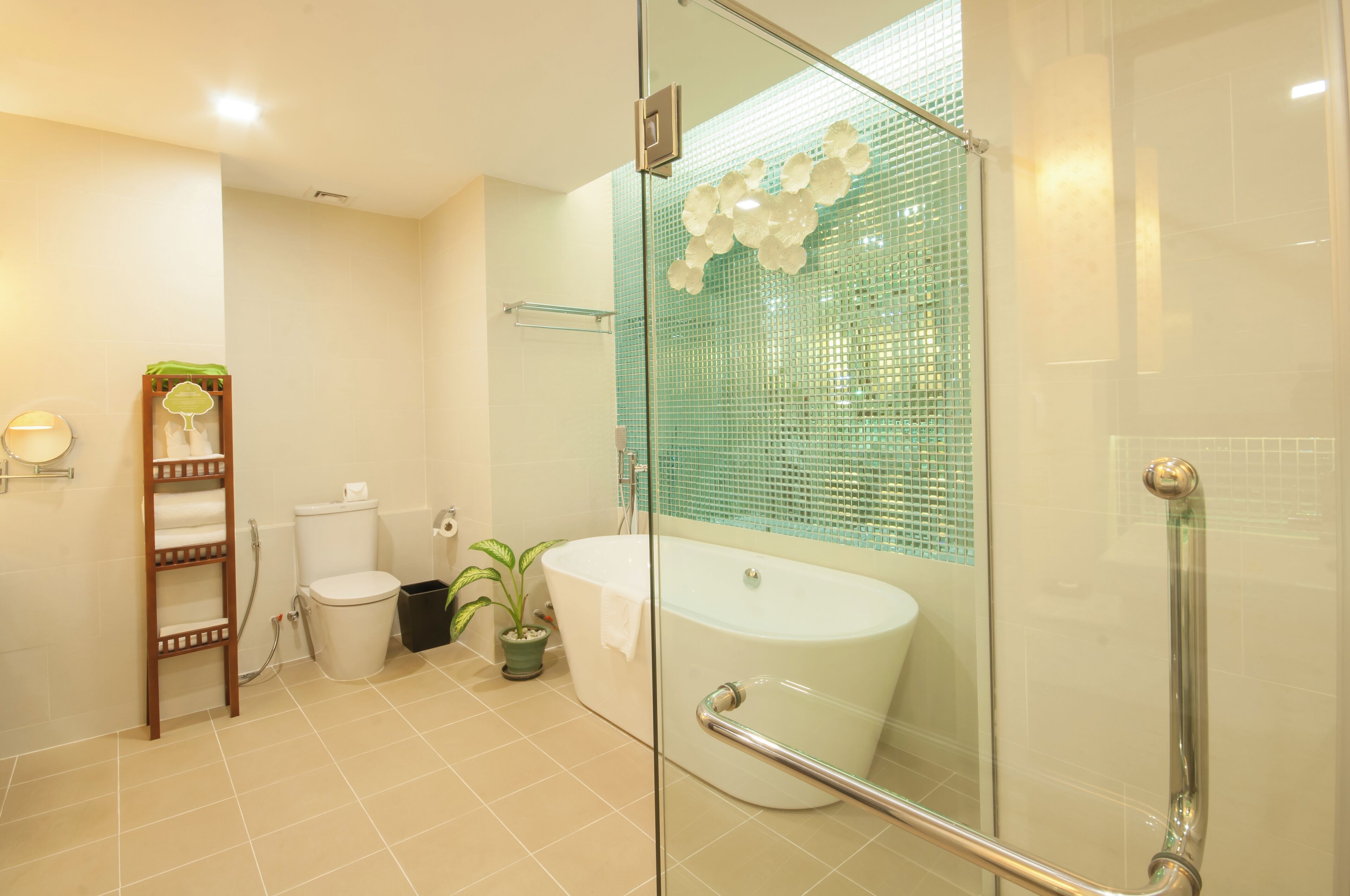 Een moderne badkamer met een douchecabine van glas, een witte badkuip en een toilet.