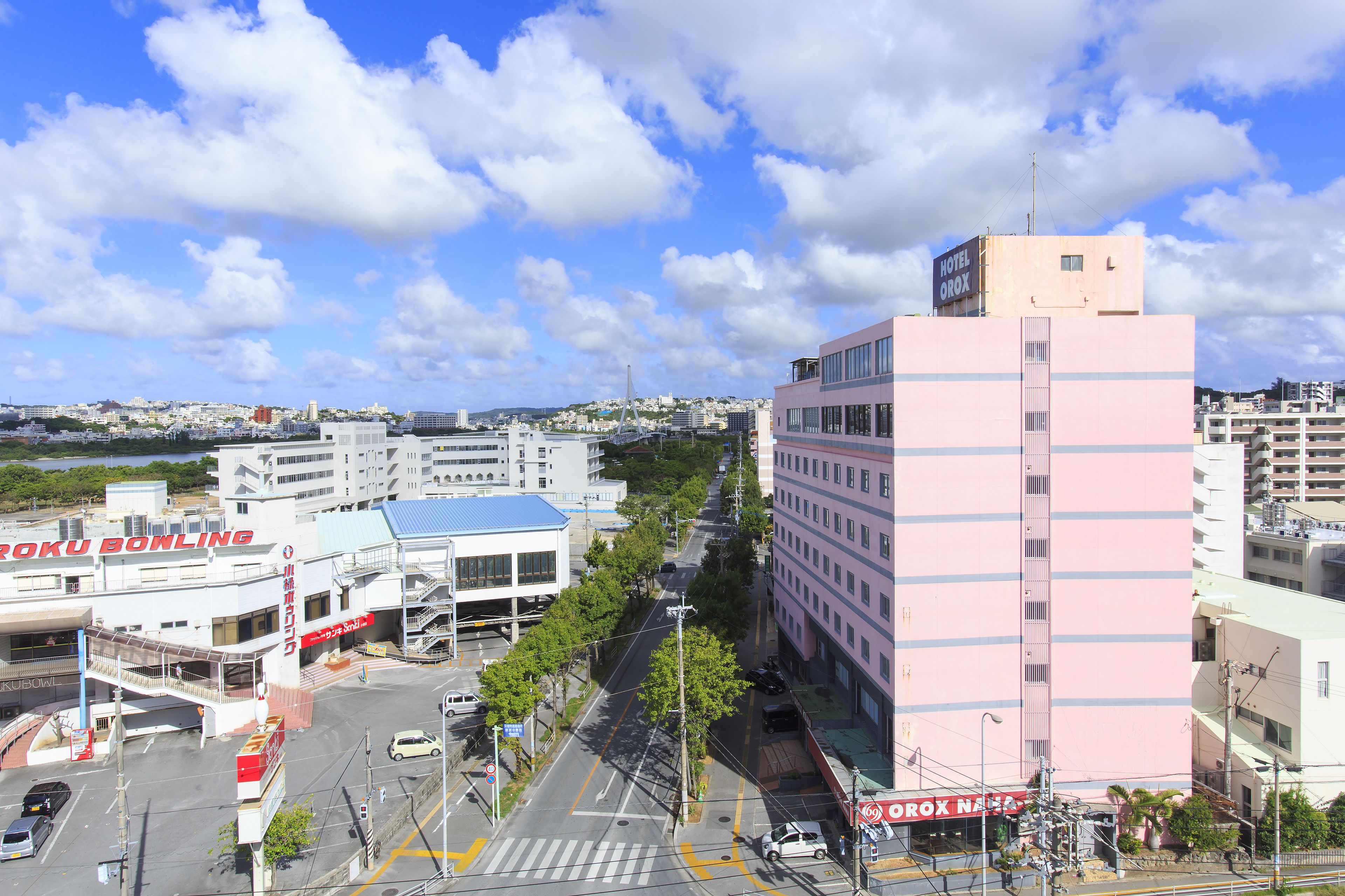 A hotel with a modern design, located in an urban area with a clear sky and a view of the cityscape.