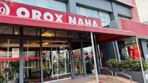 En bygnings facade med markise i rød farve og skiltet "OROX NAHA".