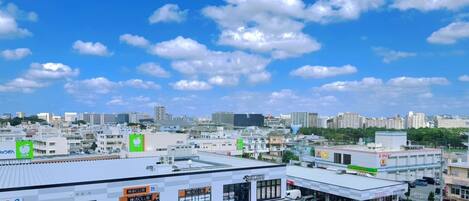 A cityscape with a clear blue sky and scattered clouds.
