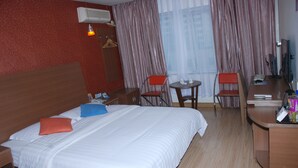 A hotel room with a bed, two chairs, a small table, a desk with a computer, and a TV. - Ane 158 Hotel Bazhong Branch (Bazhong)