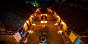 A traditional courtyard with tiled roofs and lanterns, surrounded by buildings with wooden doors and windows. - City Wall Old House.Ji Residence (Jinzhong)