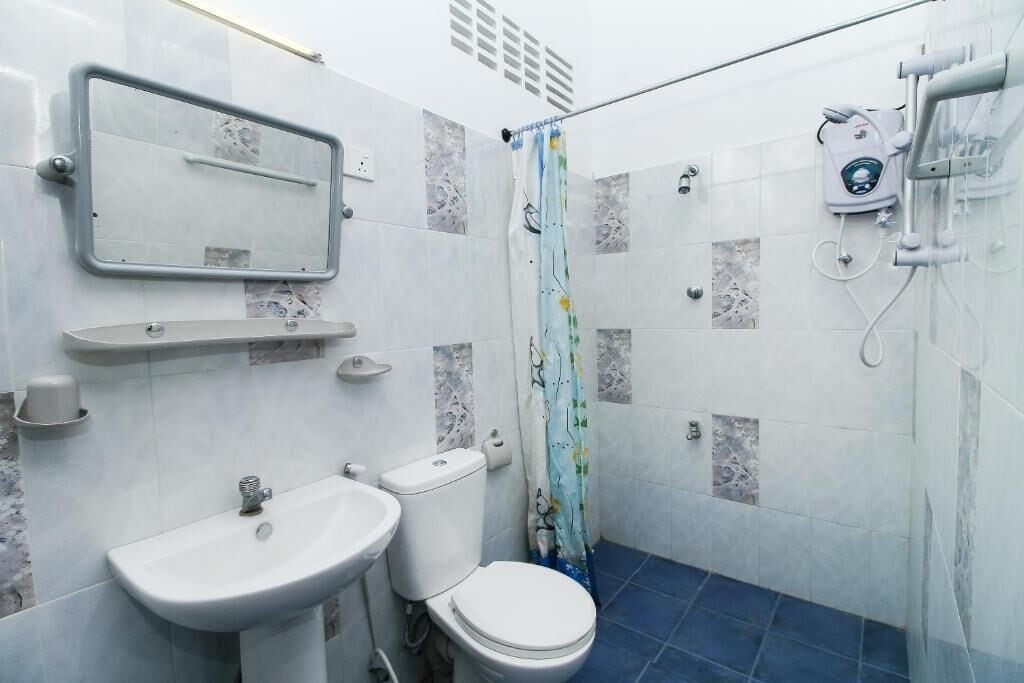 A bathroom with a toilet, sink, and shower.