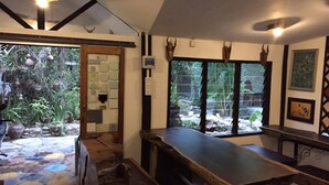 A rustic interior with a long wooden table, a bench, and a welcome mat.