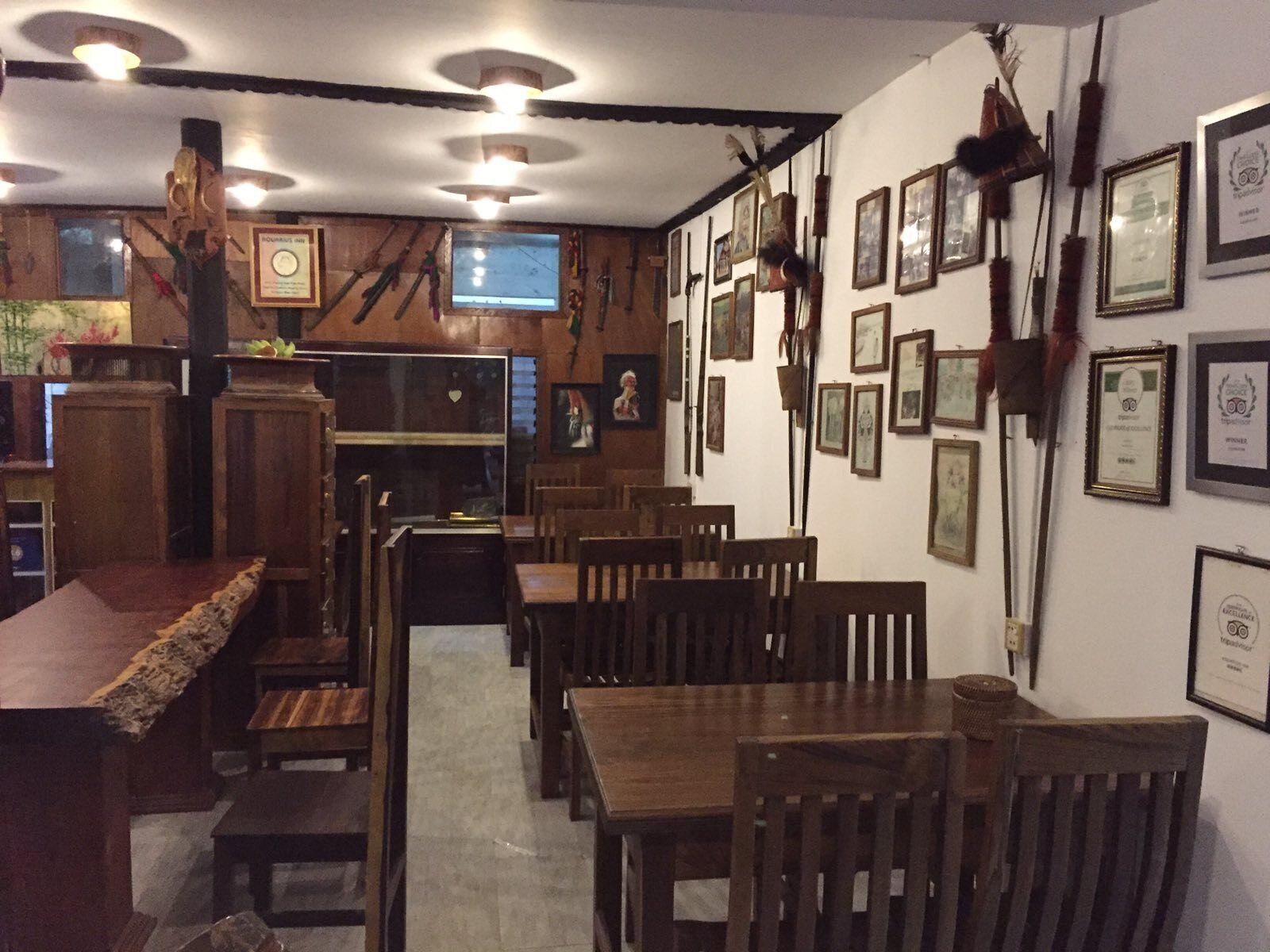 Un restaurante con mobiliario de madera, cuadros en las paredes y una pantalla de televisión.