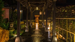 A covered stone pathway leading to a traditional building with wooden pillars and a lantern. - Hotel Shouryuen Kaisei (Kamiamakusa)