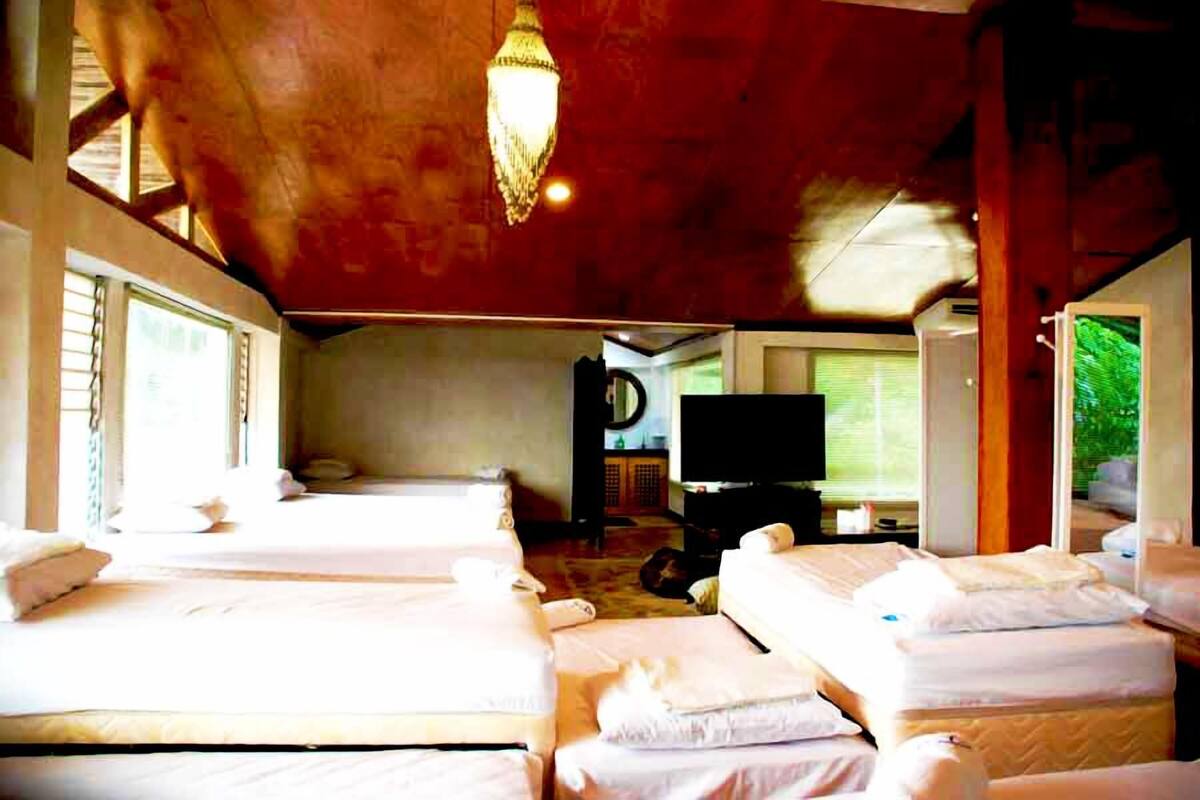 A hotel room with two beds, a television, and a large window.