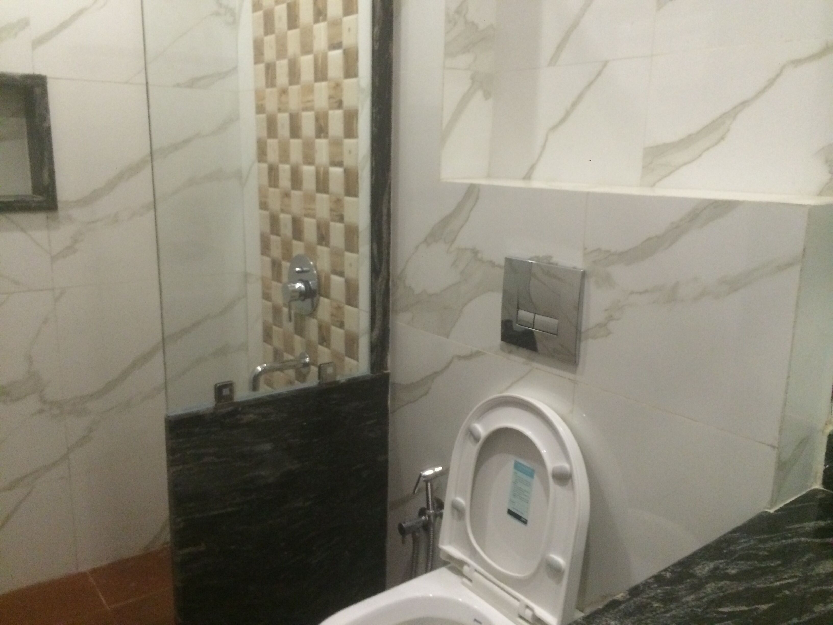 Un baño con inodoro, lavamanos, espejo y zona de ducha.