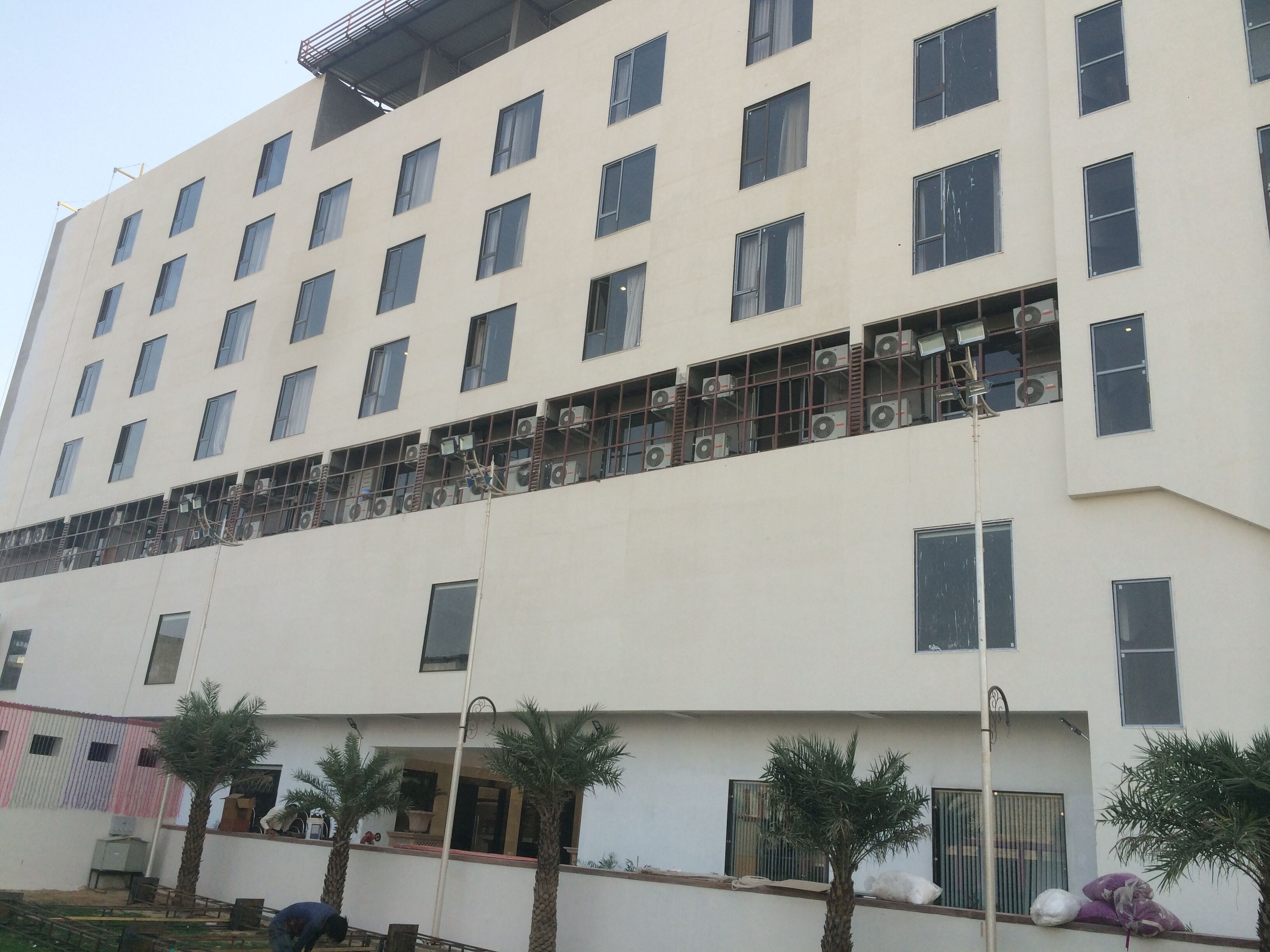 A multi-story hotel with a flat facade, numerous windows, and air conditioning units.