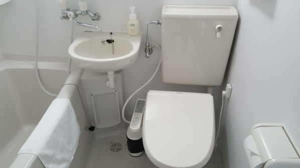 Un bagno con lavandino, water e vasca da bagno bianchi.