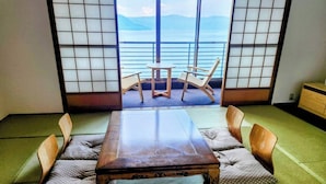 Una habitación japonesa tradicional con suelo de tatami, una mesa de madera baja y puertas correderas shoji.