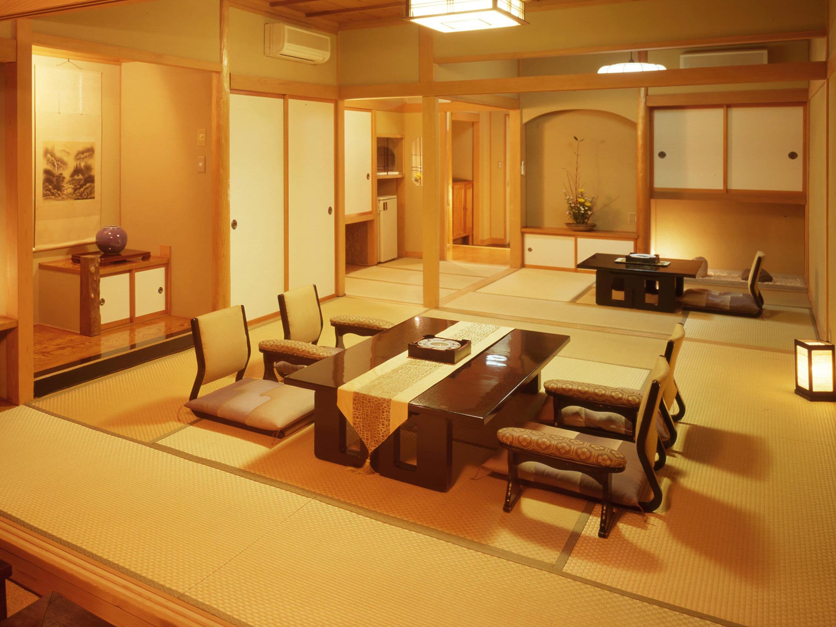A traditional Japanese room with tatami flooring, a low table with cushions, and sliding doors.