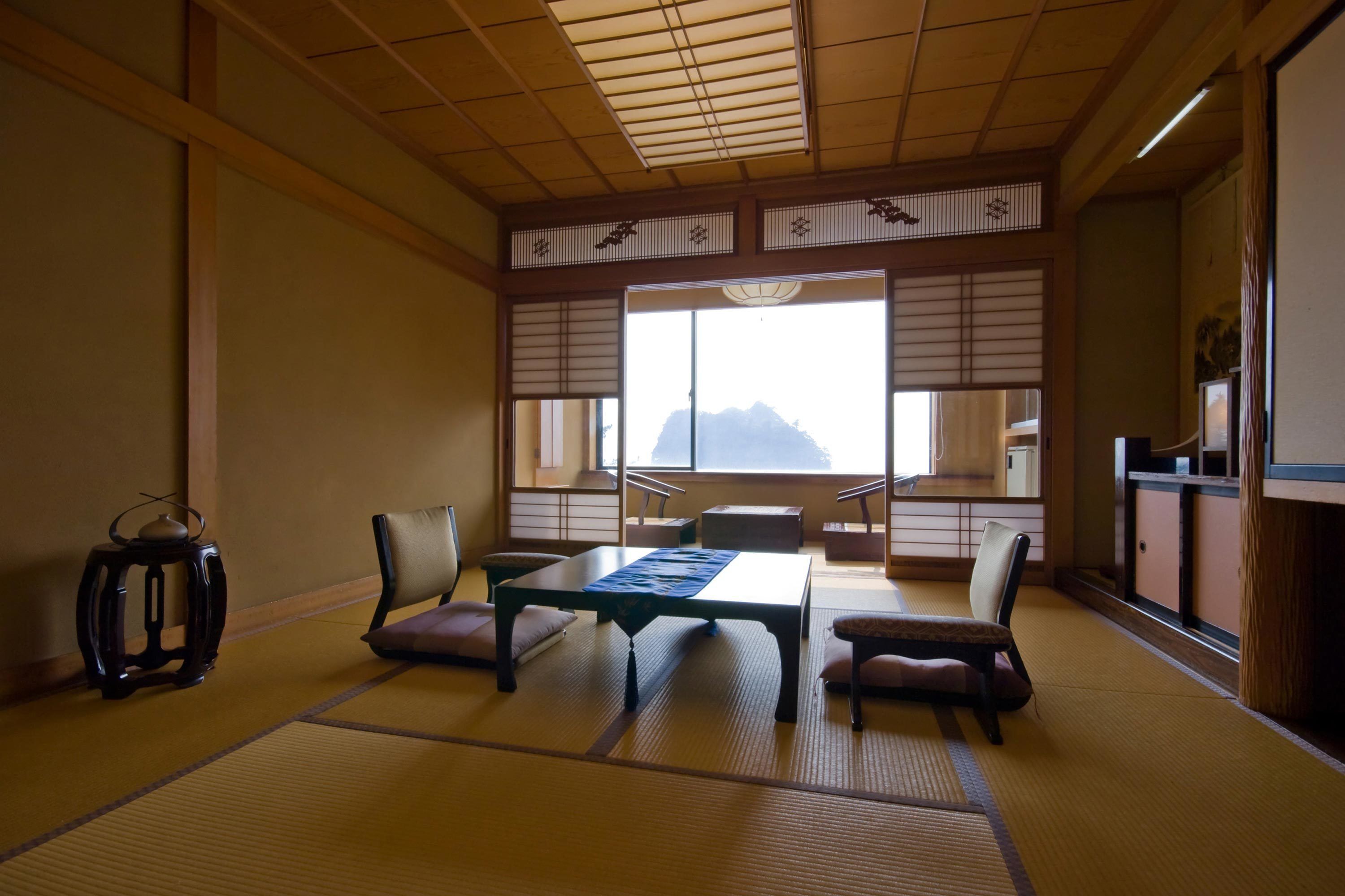 A traditional Japanese room with tatami flooring, a low table, and sliding shoji doors.