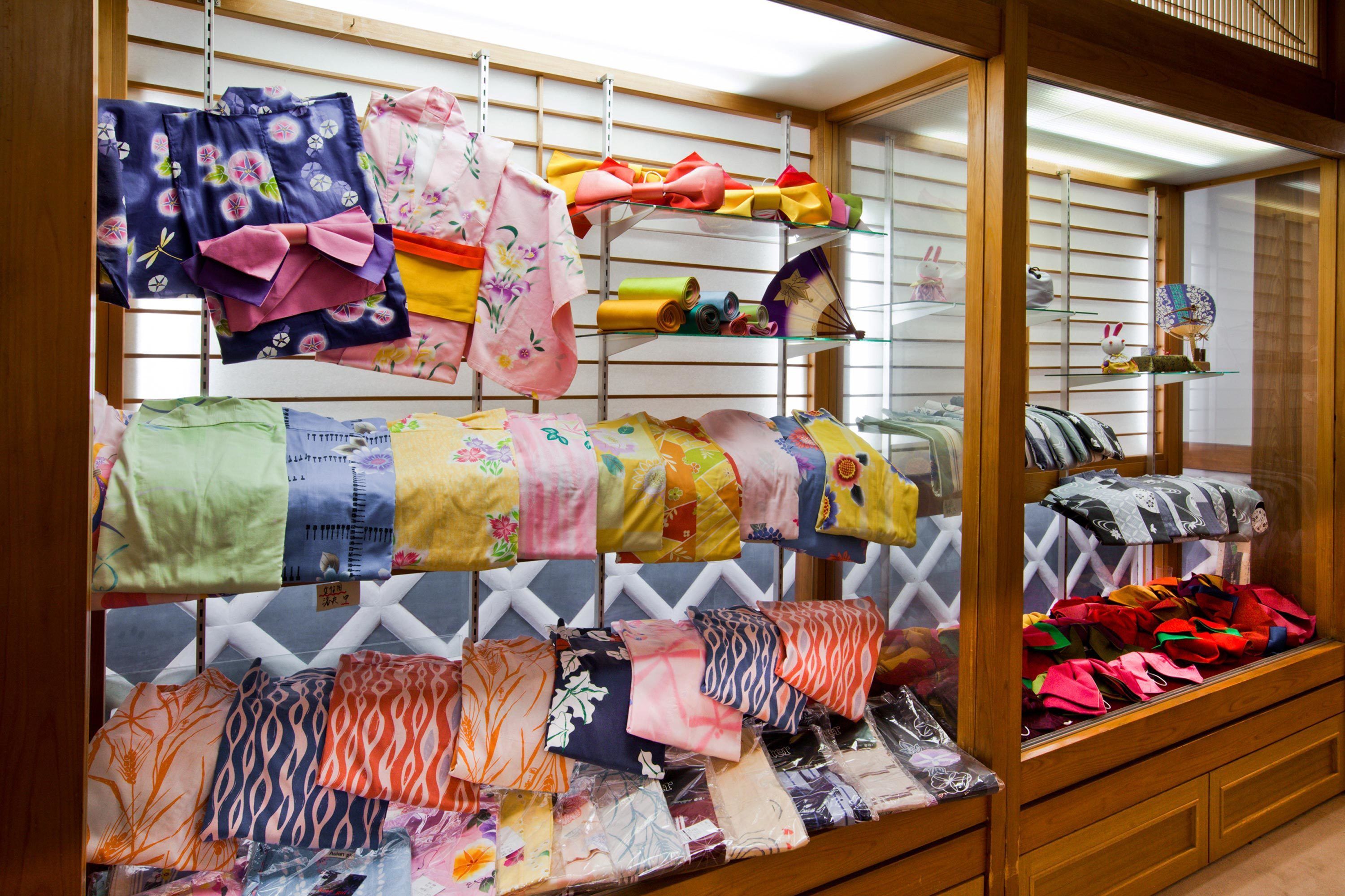 A display of various fabrics and textiles, including patterned and solid-colored options, arranged on shelves and racks.