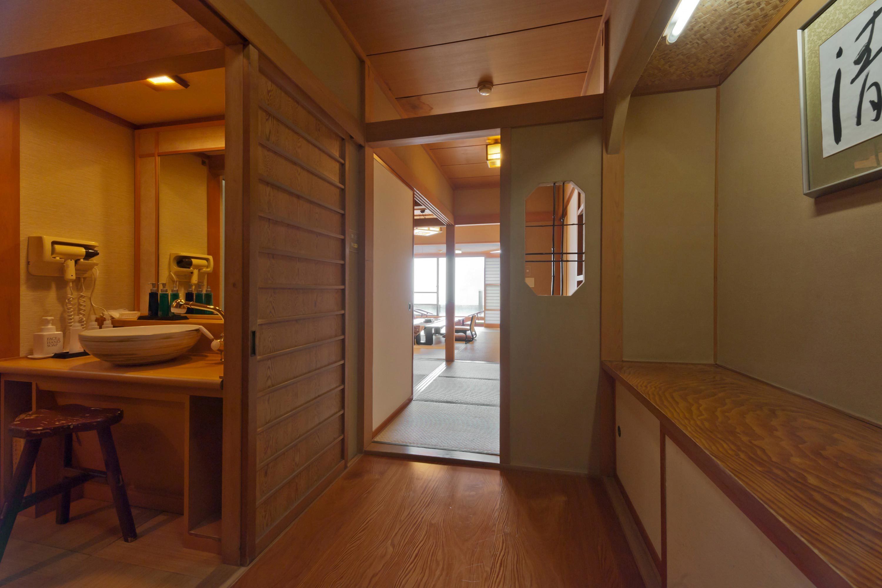 A wooden interior with a sink, stool, and a mirror.