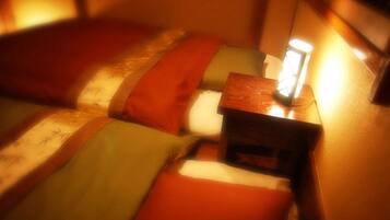 A dimly lit room with a bed and a nightstand.