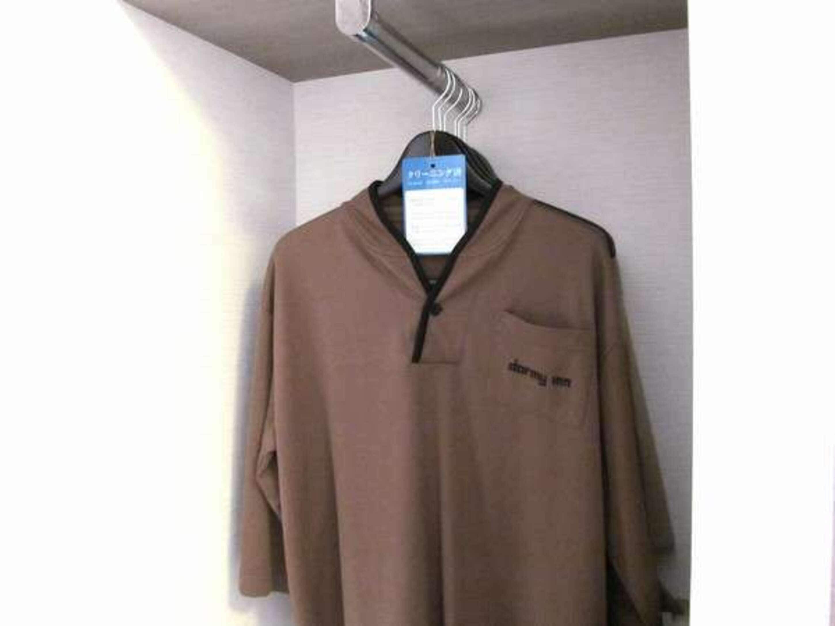 A brown shirt hanging on a hanger with a tag.