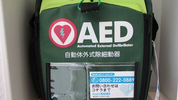 Bolsa verde y negra para desfibrilador externo automático (DEA) con un símbolo de corazón y el texto "Asahi KASEI".
