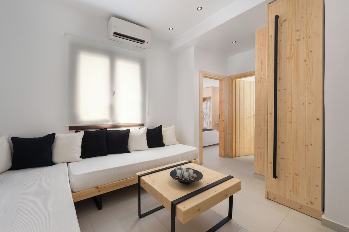 A modern living room with a sofa, a coffee table, and a wooden wardrobe.