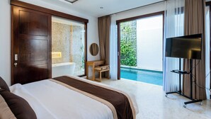 A hotel room with a large bed, a bathtub, a TV, and a balcony with a pool. - Bali Residence Villa (Ungasan)