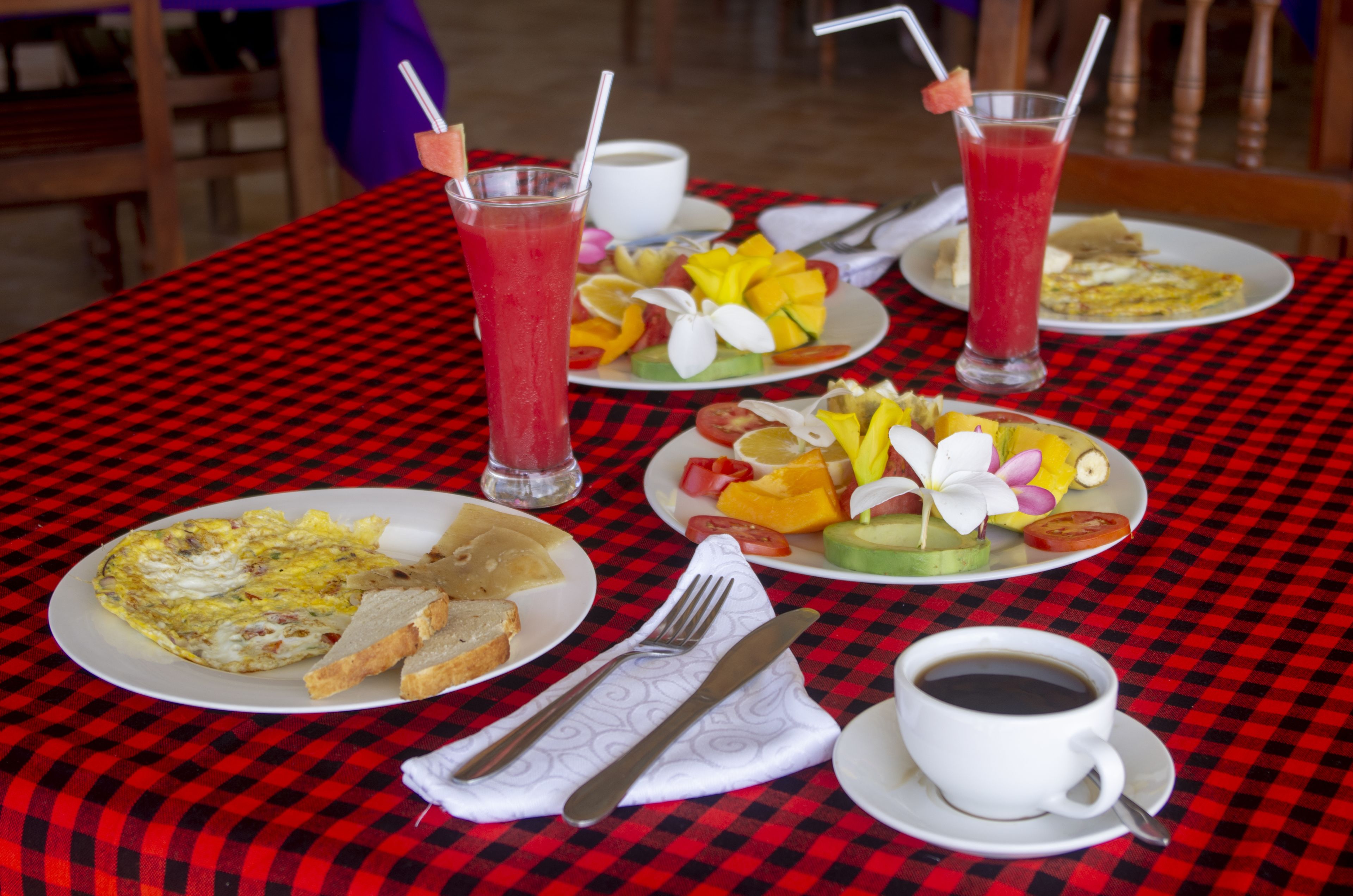 A table with breakfast items including eggs, toast, fruit, and two drinks.