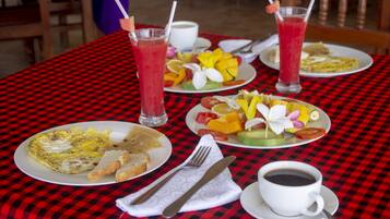 A table with breakfast items including eggs, toast, fruit, and two drinks.