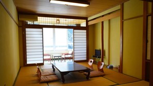 Een traditionele Japanse kamer met tatami vloeren, een lage tafel en schuifdeuren.