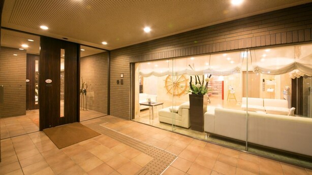 A modern hotel lobby with a reception desk, seating area, and a large window. - Hotel nanvan Yaizu (Yaizu)