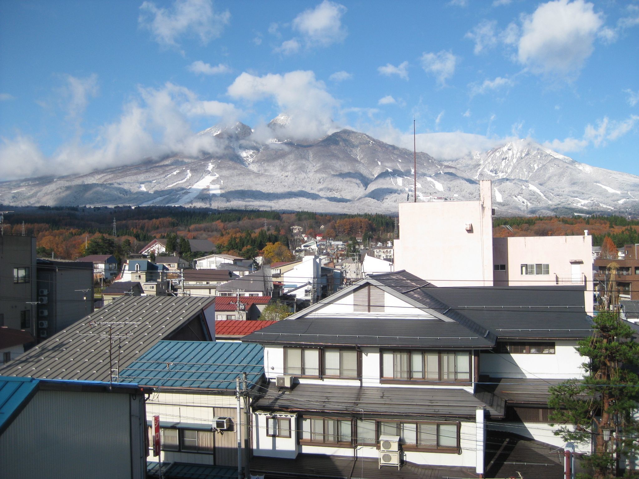 A town with buildings and a snow-capped mountain in the background.