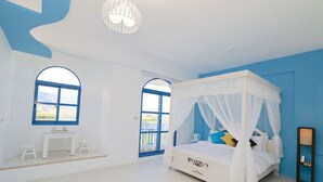 Une chambre à coucher avec un lit à baldaquin, deux fenêtres, une petite table et une table de chevet.
