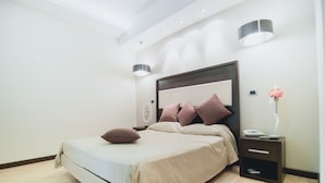 Een moderne slaapkamer met een bed, nachtkastjes en een wandlamp.