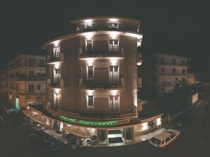Ein mehrstöckiges Hotel mit Balkonen und einem Restaurant im Erdgeschoss.