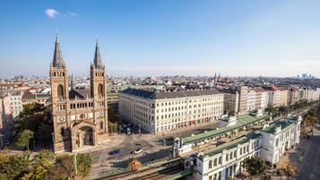 Un edificio histórico con dos torres, un cuerpo central amplio y una estructura con techo verde.