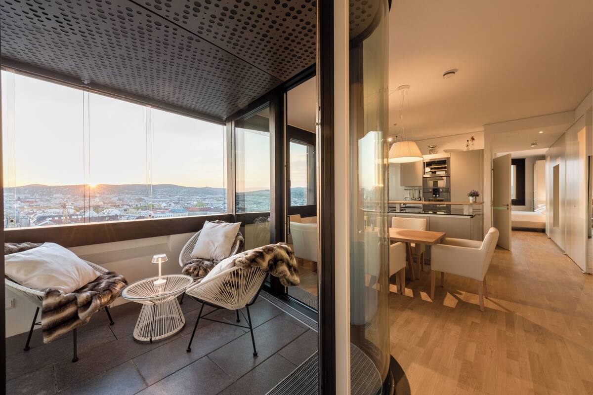 A modern interior with a balcony, dining area, and kitchen.