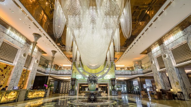 A grand lobby with a central fountain, marble floors, and a high ceiling with intricate lighting. - Sunshine Hotel Zhangjiajie (Zhangjiajie)