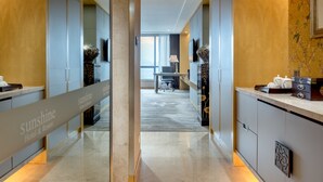 A hotel corridor with a modern design, featuring a glass partition, a reception desk, and a view of the cityscape through large windows. - Sunshine Hotel Zhangjiajie (Zhangjiajie)
