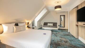 Una habitación de hotel moderna con una cama grande, un televisor, un sofá y un espejo.