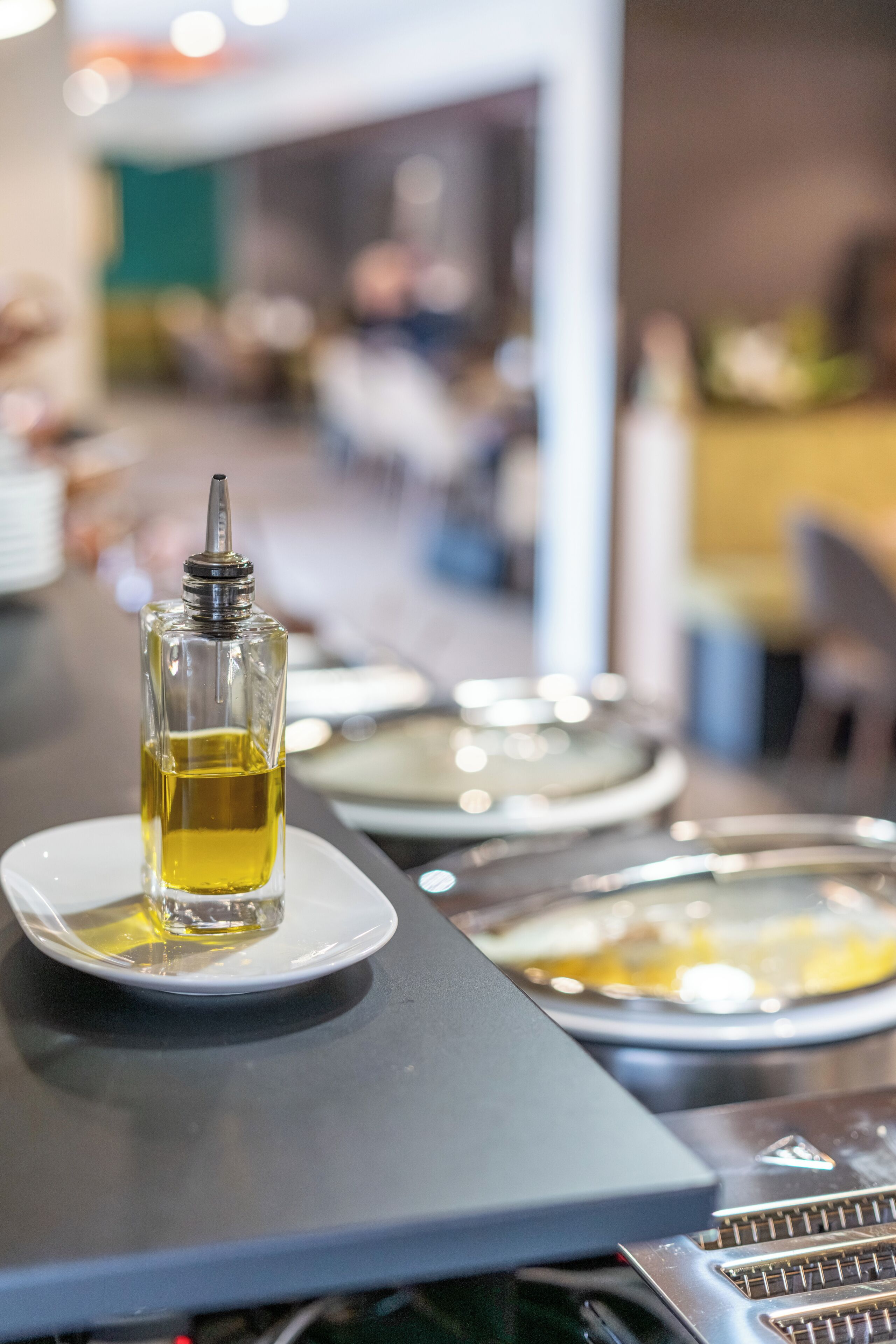 Un espace bar avec une bouteille d’alcool posée sur une assiette, un gril et un comptoir.
