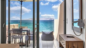 A balcony with a view of the sea, a table with chairs, a sofa, and a wooden bench. - Almare Beach Hotel (Hersonissos)
