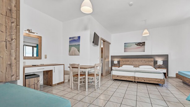 A bedroom with a bed, bedside tables, a desk, and a chair. - Almare Beach Hotel (Hersonissos)
