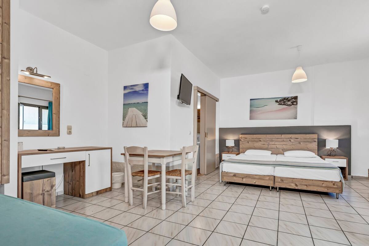 A bedroom with a bed, bedside tables, a desk, and a chair.