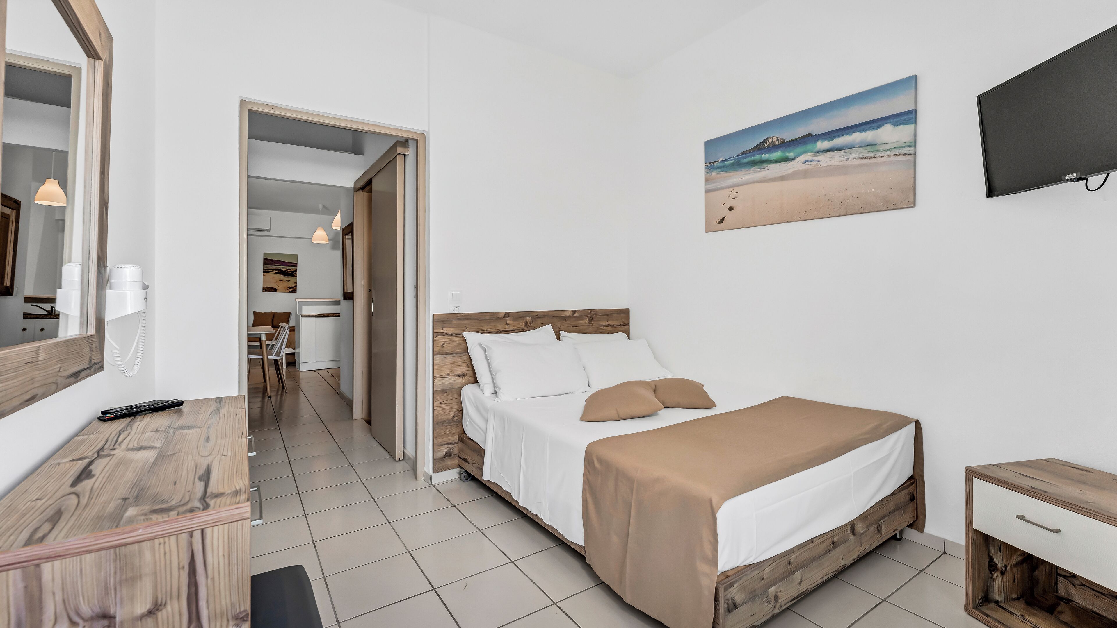Una camera da letto con un letto, un comodino e un quadro raffigurante una spiaggia.