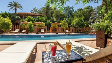 Alberca al aire libre y camastros