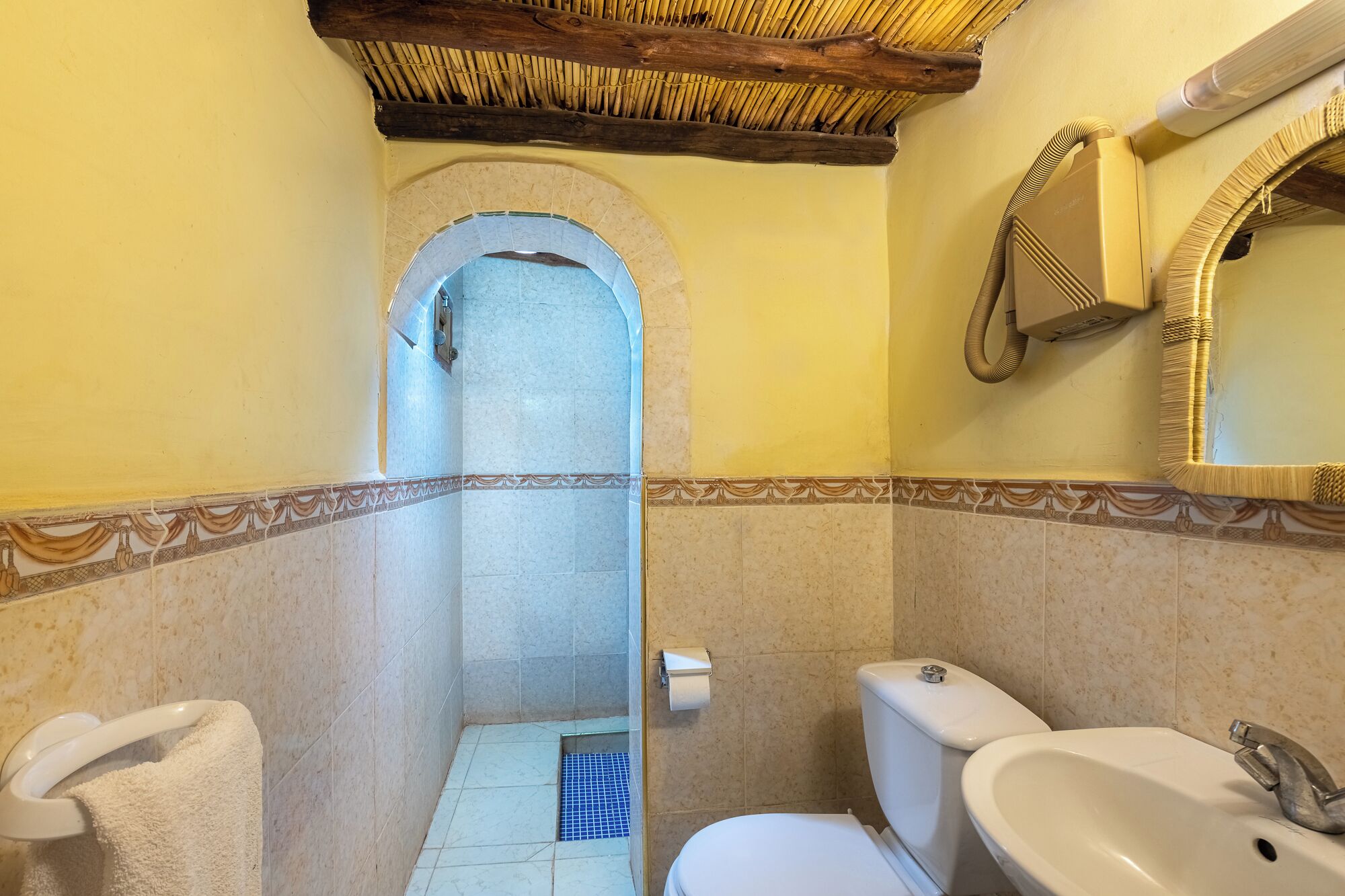 Een badkamer met toilet, wastafel en handdoekrek.