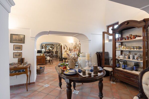 A dining area with a table set for a meal, surrounded by shelves with kitchenware.