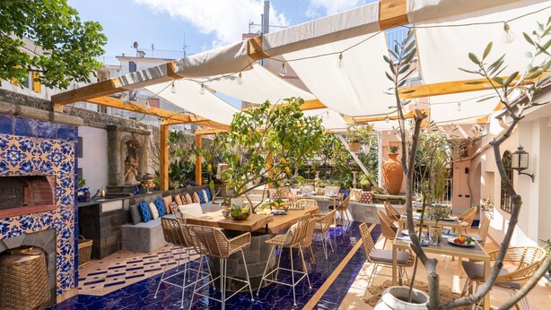 An outdoor patio with a pool, wooden furniture, and a dining area. - Maison Fernanda (Massa Lubrense)